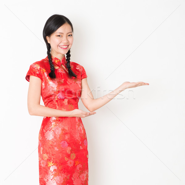Oriental girl in red qipao hand showing something Stock photo © szefei