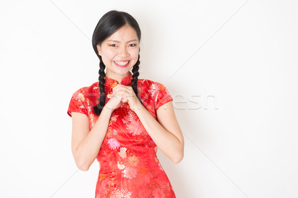 Oriental girl in red qipao greeting Stock photo © szefei