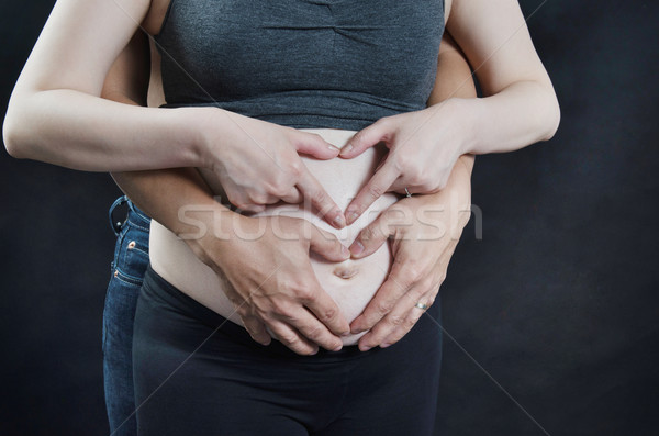 Daddy and mummy hands forming love shape  Stock photo © szefei
