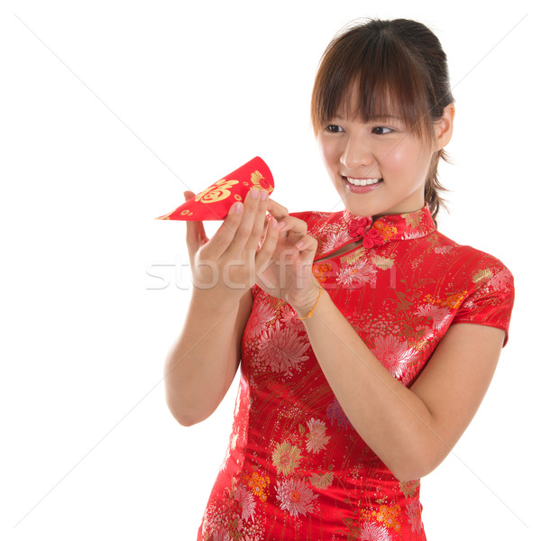 Chinese cheongsam girl peeking into red packets Stock photo © szefei