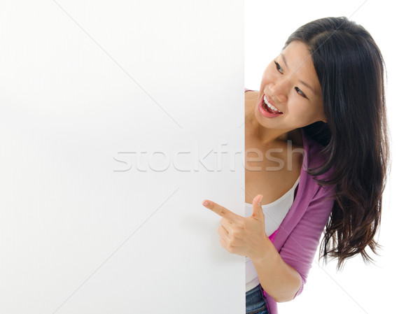 Asian woman pointing to blank billboard.  Stock photo © szefei