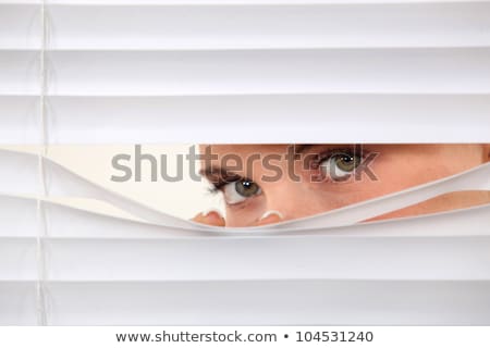 Foto stock: Woman Peering Through Blinds
