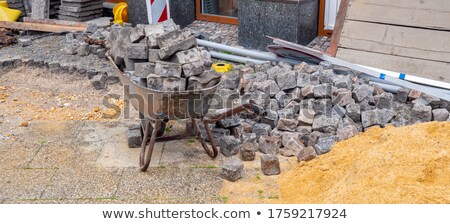 Foto stock: Craftsman Putting Stones In A Wheelbarrow