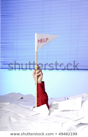 Foto stock: E · la · mano · con · la · bandera · de · ayuda · que · sobresale · de · los · papeles