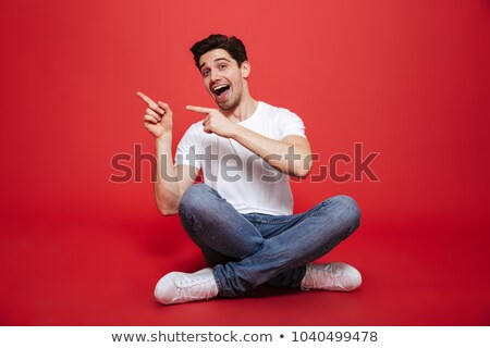 Stok fotoğraf: Seated Happy Casual Man Pointing Fingers