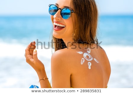 Foto stock: Woman Body With Sun Shaped Sun Cream