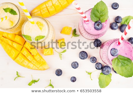 Сток-фото: Violet Blueberry Fruit Smoothie In Glass Jars With Straw Mint Leaves Berries Close Up Top View