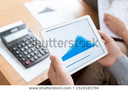 Сток-фото: Human Hands Holding Touchpad With Blue Graph Of Financial Rate On Display