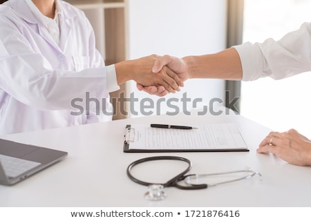 Foto d'archivio: Attractive Doctor And Patient Shaking Hands For Encouragement An