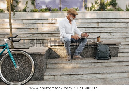 Foto stock: Portrait Of A Young Man With Laptop Outdoor Sitting On Bench
