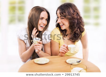 Foto stock: Two Beautiful Women Drinking Coffee And Chatting At Mall Cafe