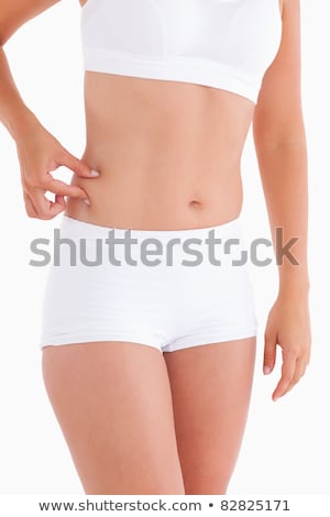 Сток-фото: Smiling Woman Gripping Her Waist In A Studio