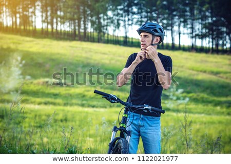 ストックフォト: Adult Bicyclist Put Helmet On