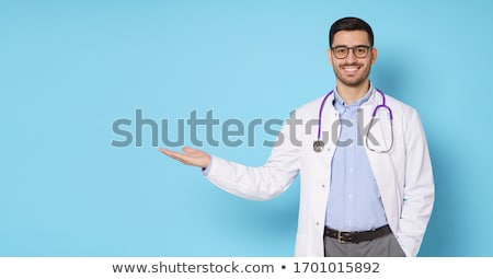 Foto d'archivio: Young Smiling Doctor Pointing Copy Space