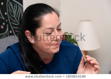 Stok fotoğraf: Guilty Woman On Diet Eating Chocolate Bar At Home