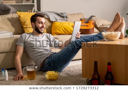 Сток-фото: Man Drinking A Beer Sitting In The Sofa