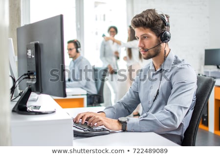 Stockfoto: Man Working At Computer In Call Centre