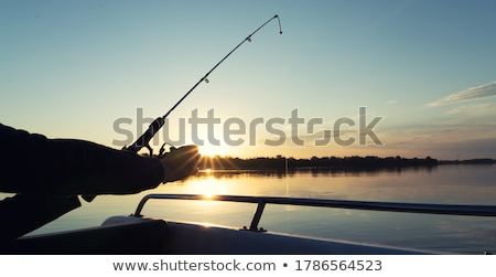Zdjęcia stock: Woman Fishing On Fishing Rod Spinning At Sunset Background