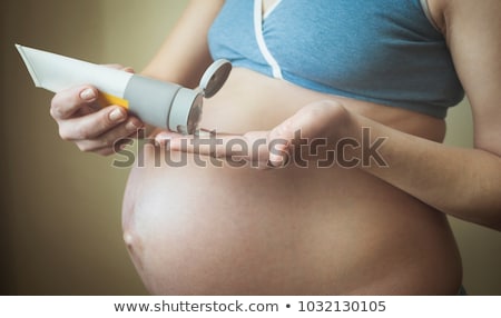 Stockfoto: Pregnant Woman Putting Cream On Her Belly