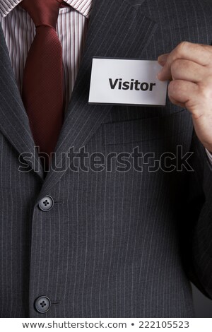 Foto stock: Businessman Attaching Visitor Badge To Jacket