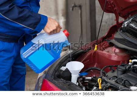 ストックフォト: Serviceman Pouring Windshield Washer Fluid Into Car