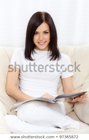 Сток-фото: Young Brunette Woman Sitting On The Chair And Reading Magazine