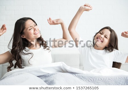 Foto d'archivio: Girl In Pajamas Woke Up In The Morning Is Sitting On A Bed