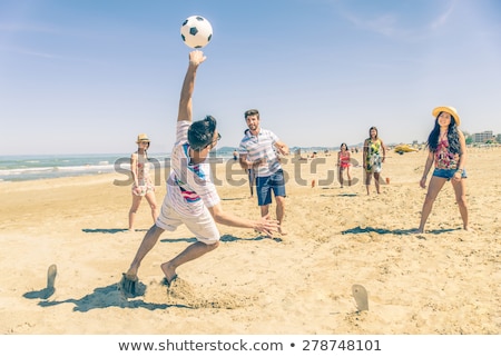 Foto stock: Friends Playing With Beach Ball In Summer