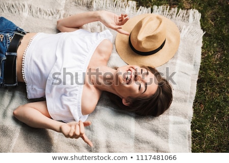 Stok fotoğraf: Smiling Young Girl Laying On Grass At The Park