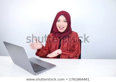 Foto d'archivio: Young Asian Islam Woman Is Smiling Pointing Hand When Working On Laptop On White Background