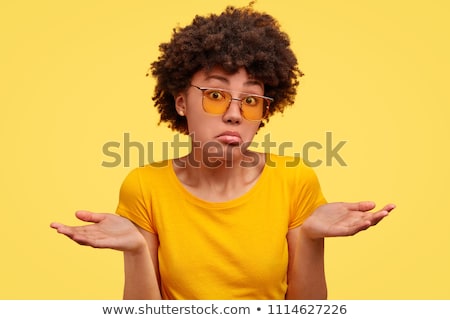 Zdjęcia stock: Portrait Of A Puzzled Young Girl Shrugging Shoulders