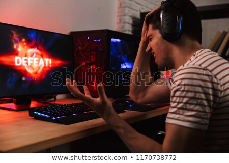 Foto stock: Side View Of Confused Gamer Playing Video Games On Computer
