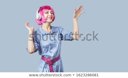 Foto d'archivio: Cheerful Young Woman Wearing Colorful Dress And Blue Wig