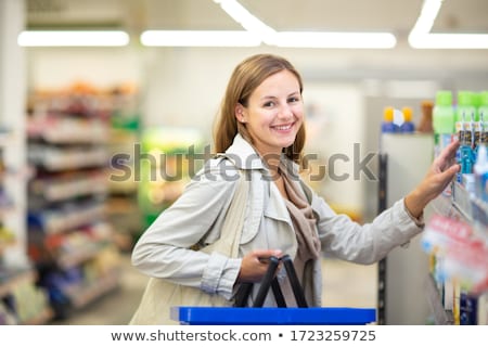 Foto stock: Pretty Young Woman Buying Groceries In A Supermarket