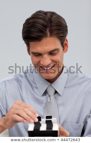 [[stock_photo]]: Smiling Businessman Consulting A Business Card Holder