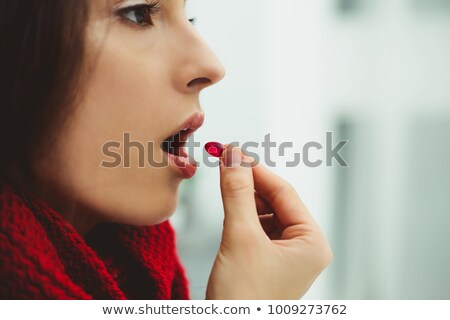 Foto stock: Woman With A Pill In Her Mouth