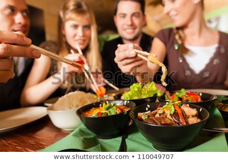 Young People Eating Food In Thai Restaurant Stockfoto © Kzenon