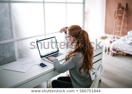 ストックフォト: Young Beautiful Woman With Red Hair Wearing Glasses Working In The Office Uses A Laptop And Mobil