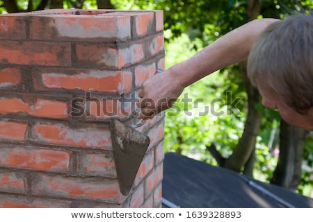 Foto d'archivio: Mason Working On A Chimney