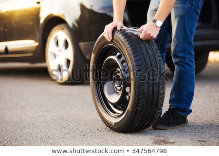 [[stock_photo]]: Mechanic With A Spare Tyre