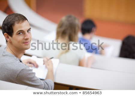 Imagine de stoc: Smiling Students Listening A Lecturer In An Amphitheater