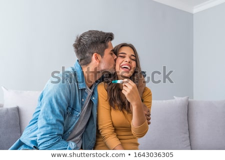 Foto stock: Happy Smiling Woman Holding And Showing Positive Home Pregnancy