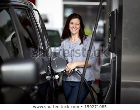 Stock photo: Woman Fills Petrol Into Her Car At A Gas Station