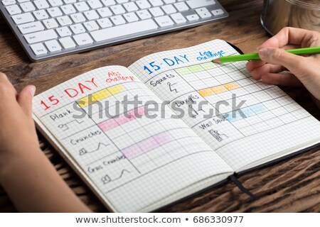 Stock foto: Person Making Note Of Workout Plan On Notebook