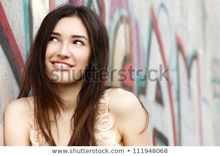 Foto stock: Young And Beautiful Girl Posing Against Graffiti Wall