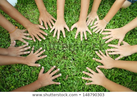 Foto stock: Arms Of Children Together In Circle On Green Background