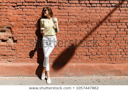 Foto stock: Girl Posing On A Background Of Red Brick Wall