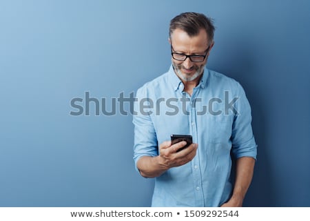 Foto d'archivio: Man Reading A Message On His Mobile Phone