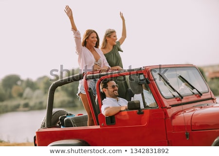 ストックフォト: Young People Having Fun In Convertible Car By River