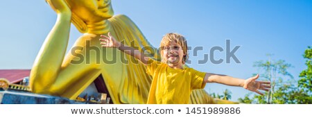 Zdjęcia stock: Happy Boy Tourist On Background Oflying Buddha Statue